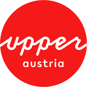 Logo Oberösterreich Tourismus: red circle with white upperaustria lettering